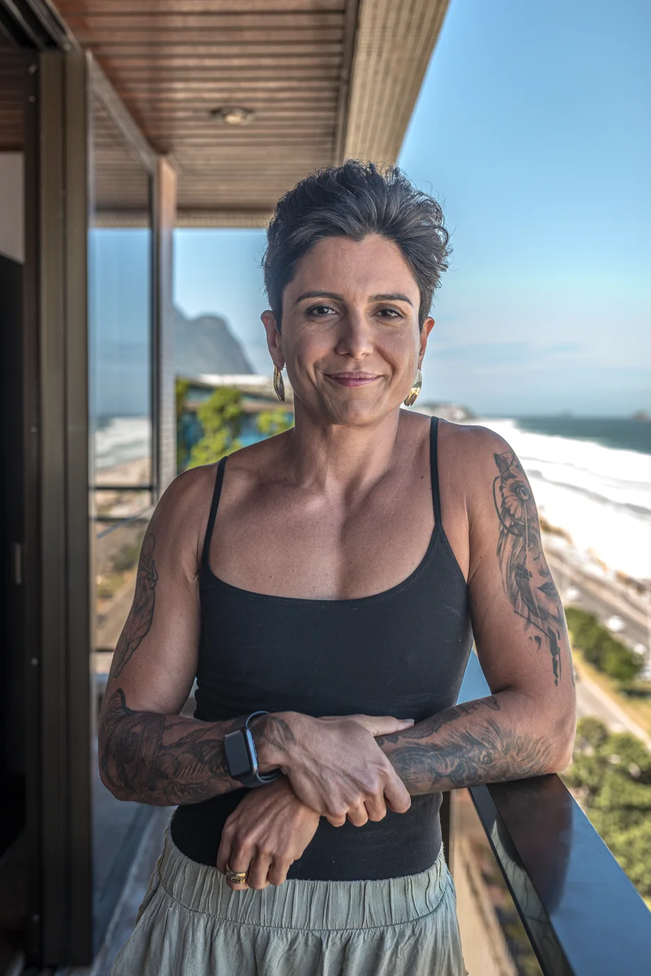 Nanny Faggiano sorrindo na varanda, com o mar ao fundo